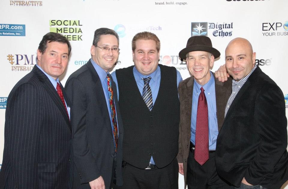 Basil Puglisi with four guests at a Social Media Week event, in front of a sponsor wall with Digital Ethos and CorbettPR.com