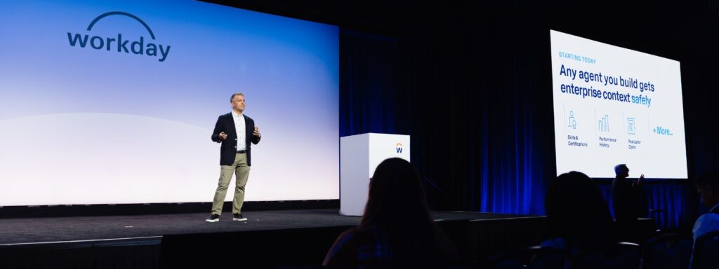 Workday Rising 2026 keynote stage with a slide reading Any agent you build gets enterprise context safely