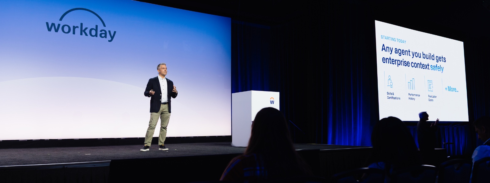 Workday Rising 2026 keynote stage with a slide reading Any agent you build gets enterprise context safely